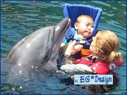 Junger Mann mit Schwimmweste bei der Delfin-Therapie